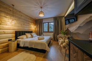 1 dormitorio con 1 cama en una pared de madera en Willa Zielone Wzgórze - Luksusowe apartamenty - Zakopane, en Zakopane