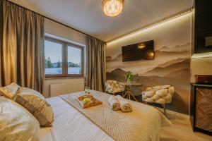 a bedroom with a bed with a tray of food on it at Willa Zielone Wzgórze - Zakopane - Luksusowe apartamenty in Zakopane