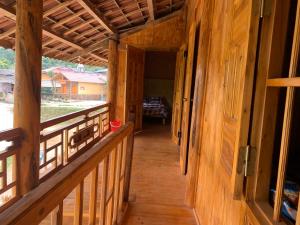 a hallway of a wooden house with a porch at Hoàng nam Homestay in Quang Ba