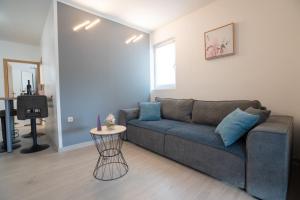 a living room with a couch and a table at Apartment Danka - parking and grill in Novalja