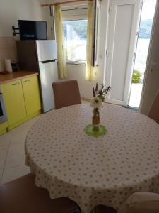 uma cozinha com uma mesa com um vaso de flores em Apartment More 1 - sea front em Savar