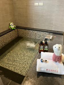 - un ours en peluche assis sur une serviette dans la salle de bains dans l'établissement Now and Then Hot Spring Inn, à Jiaoxi