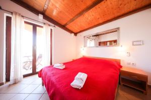 een slaapkamer met een rood bed en 2 handdoeken erop bij Apartments Vesna - 200 m from beach in Bibinje
