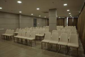a room with rows of white chairs in it at Dreamotel Luxury Suites in Kanjikode
