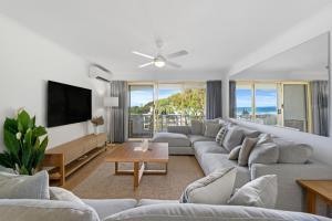 a living room with a couch and a tv at The Hill Apartments Currumbin Beach in Gold Coast