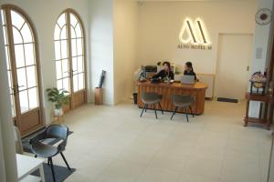 two people sitting at a desk in a waiting room at Alto Hotel M in Mae Sot