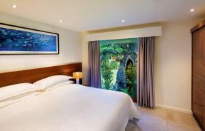 a bedroom with a bed and a large window at Sheraton Resort & Spa, Tokoriki Island, Fiji in Tokoriki