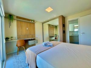 ein Schlafzimmer mit einem großen weißen Bett und einem Stuhl in der Unterkunft Atlântida Green Square - 408B in Xangri-lá