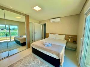 1 Schlafzimmer mit 2 Betten und einer Glasschiebetür in der Unterkunft Atlântida Green Square - 408B in Xangri-lá