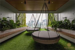 2 columpios en un balcón con césped verde en Ceylonz Suite, Bukit Bintang, Experience, en Kuala Lumpur