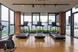 een fitnessruimte met diverse loopbanden en grote ramen bij Ceylonz Suite, Bukit Bintang, Experience in Kuala Lumpur