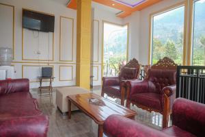 a living room with red chairs and a table at RedDoorz Syariah near Gerbang Dieng 2 in Dieng