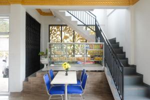 a dining room with a table and blue chairs at RedDoorz Syariah near Gerbang Dieng 2 in Dieng