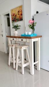 a table and stools in a kitchen with a refrigerator at monoambiente Gascón in Mar del Plata +5 photos