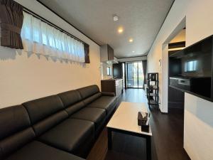 uma sala de estar com um sofá e uma mesa em 温泉付き貸別荘 風車村 E-10 with hot spring em Takashima