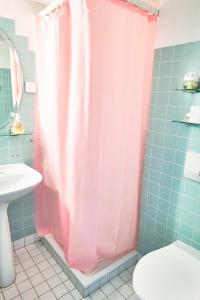 a bathroom with a shower with a pink shower curtain at Sweet Room by Interlaken in Därligen