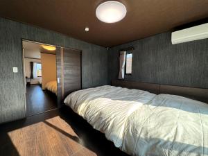 sypialnia z dużym łóżkiem i lustrem w obiekcie 温泉付き貸別荘 風車村 E-10 with hot spring w mieście Takashima