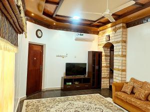 a living room with a television and a couch at Mountain Balcony House in Nizwa