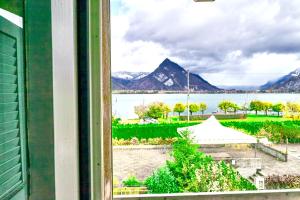 a view of a lake and mountains from a window at Sweet Room by Interlaken in Därligen