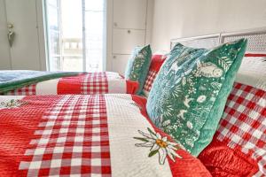 2 letti con lenzuola e cuscini a quadri rossi e bianchi di Sweet Room by Interlaken a Därligen
