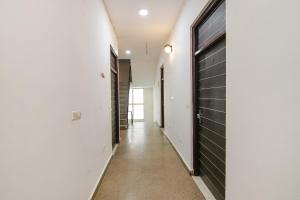 新德里的住宿－FabExpress Gross Plaza，一条带白色墙壁和黑色门的走廊