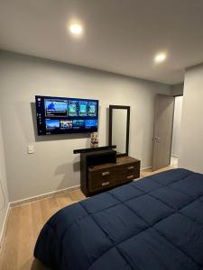 ein Schlafzimmer mit einem Bett und einem TV an der Wand in der Unterkunft Coahuila in Mexiko-Stadt