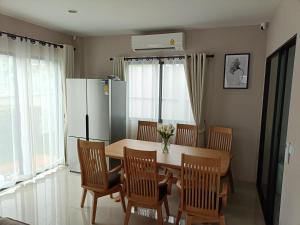 a kitchen with a table and chairs and a refrigerator at 88house suratthani in Suratthani