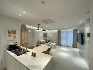 um quarto com uma cozinha e uma sala de estar em HOTEL THE DESIGNERS LYJ SUITE YEOKSAM em Seul