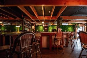 ein Restaurant mit Stühlen und eine Bar mit grünen Wänden in der Unterkunft Auberge de la Vieille Maison in Rimouski