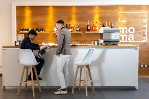 two people standing at a counter at a bar at Moma Hotel Wellness & Spa in Lavello