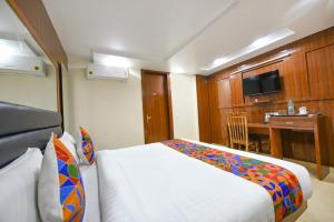 a hotel room with a bed and a desk at FabHotel Mona International in New Delhi