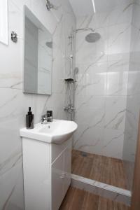 a white bathroom with a sink and a shower at kavala squareview in Kavala