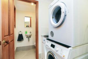 a laundry room with a washer and dryer at Granite Views Beachfront Apartment + WiFi in Encounter Bay