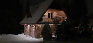 una pequeña casa en la nieve por la noche en Domki u Bobaków, en Ząb