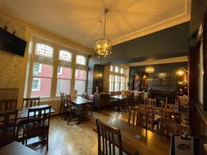 a dining room with tables and chairs and windows at The Station Hotel Penrith in Penrith