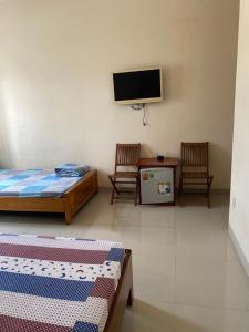 a room with two beds and a flat screen tv at Nhà Nghỉ 529 in Vung Tau