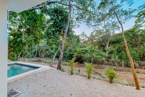 une piscine extérieure avec des arbres en arrière-plan dans l'établissement Casa Sabor a Mar, à Playa Conchal