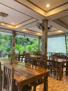 a dining room with wooden tables and chairs at Khao Sok Nature Resort in Khao Sok National Park