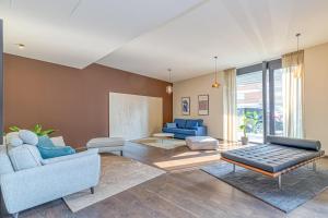 uma sala de estar com cadeiras azuis e um sofá em ICON H - Luxury Business Suite & Apartments em Lugano