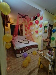 een slaapkamer met ballonnen aan de muur en een bed bij Bluestar cottage in Matheran