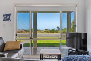 a living room with a couch and a large window at Esplanade Beachfront Victor Harbor in Victor Harbor