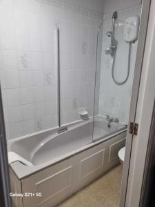een witte badkamer met een bad en een toilet bij The Station Hotel Penrith in Penrith