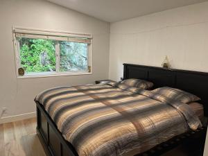 una camera da letto con un grande letto e una finestra di Tranquil Haven of Natural Beauty a West Vancouver