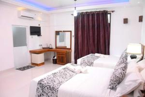 um quarto de hotel com duas camas e um espelho em blooming hotel em Anuradhapura