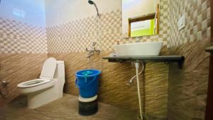 a bathroom with a white toilet and a sink at Fishing owl Home Stay in Kālādhūngi