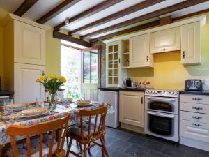 a kitchen with a table and chairs and a kitchen with yellow walls at 2 Bed in Fowey LTBUZ in Cardinham