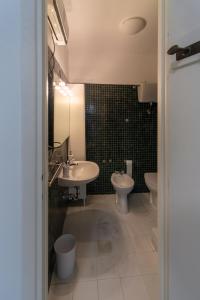 a bathroom with two sinks and a toilet and a mirror at Eur - Penthouse in Rome