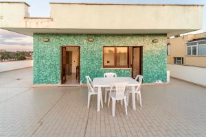 una mesa y sillas en la azotea de un edificio en Eur - Penthouse, en Roma