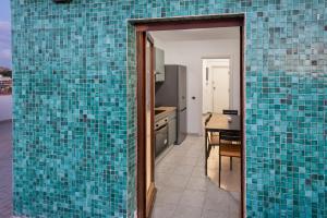 a kitchen with blue tiles on the walls at Eur - Penthouse in Rome +16 photos