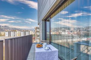 a balcony with a table and a view of a city at ICON H - Luxury Business Suite & Apartments in Lugano